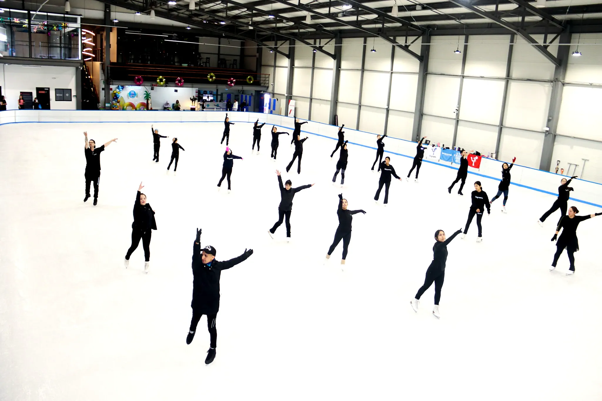 Grupo de patinadores de Ice Gravity entrenando juntos sobre la pista de hielo