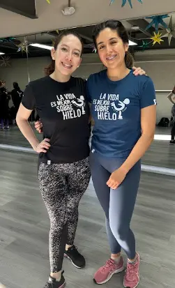 Dos mujeres adultas sonriendo juntas durante su entrenamiento en Ice Gravity