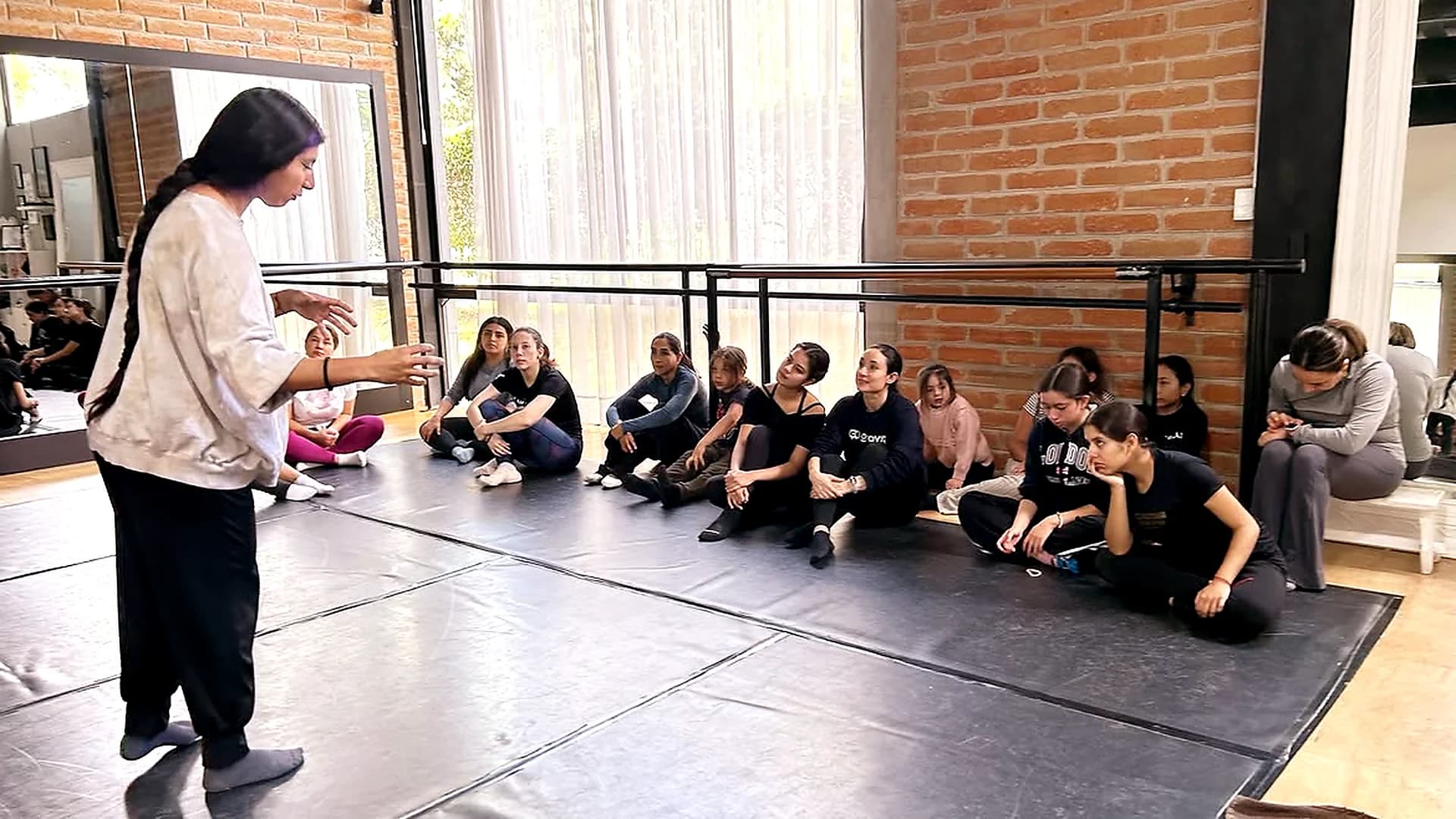 Entrenadora guiando a un grupo de patinadoras de Ice Gravity durante una sesión de formación fuera de la pista